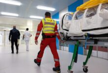 A paramedic transporting a patient following an evacuation.