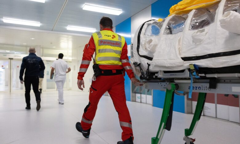 A paramedic transporting a patient following an evacuation.