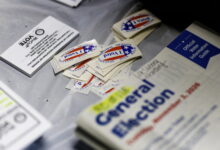 A 'I voted' sticker rests on a table next to a secure ballot box during early voting.